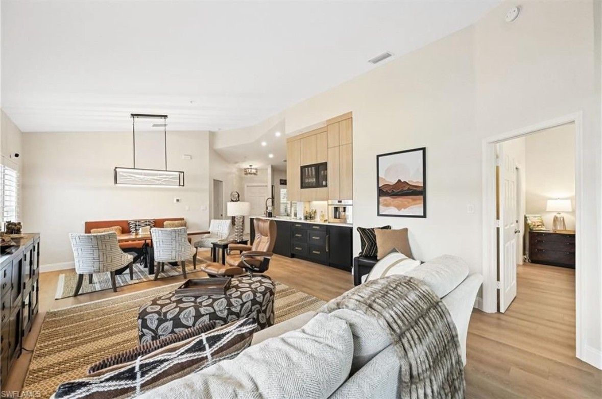 A living room with a couch , chairs , and a rug.