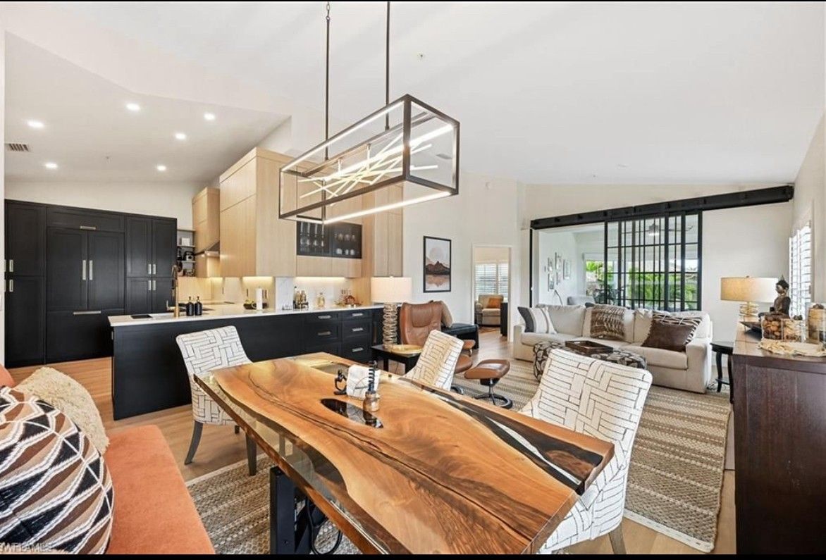 A living room with a dining table and chairs and a kitchen.