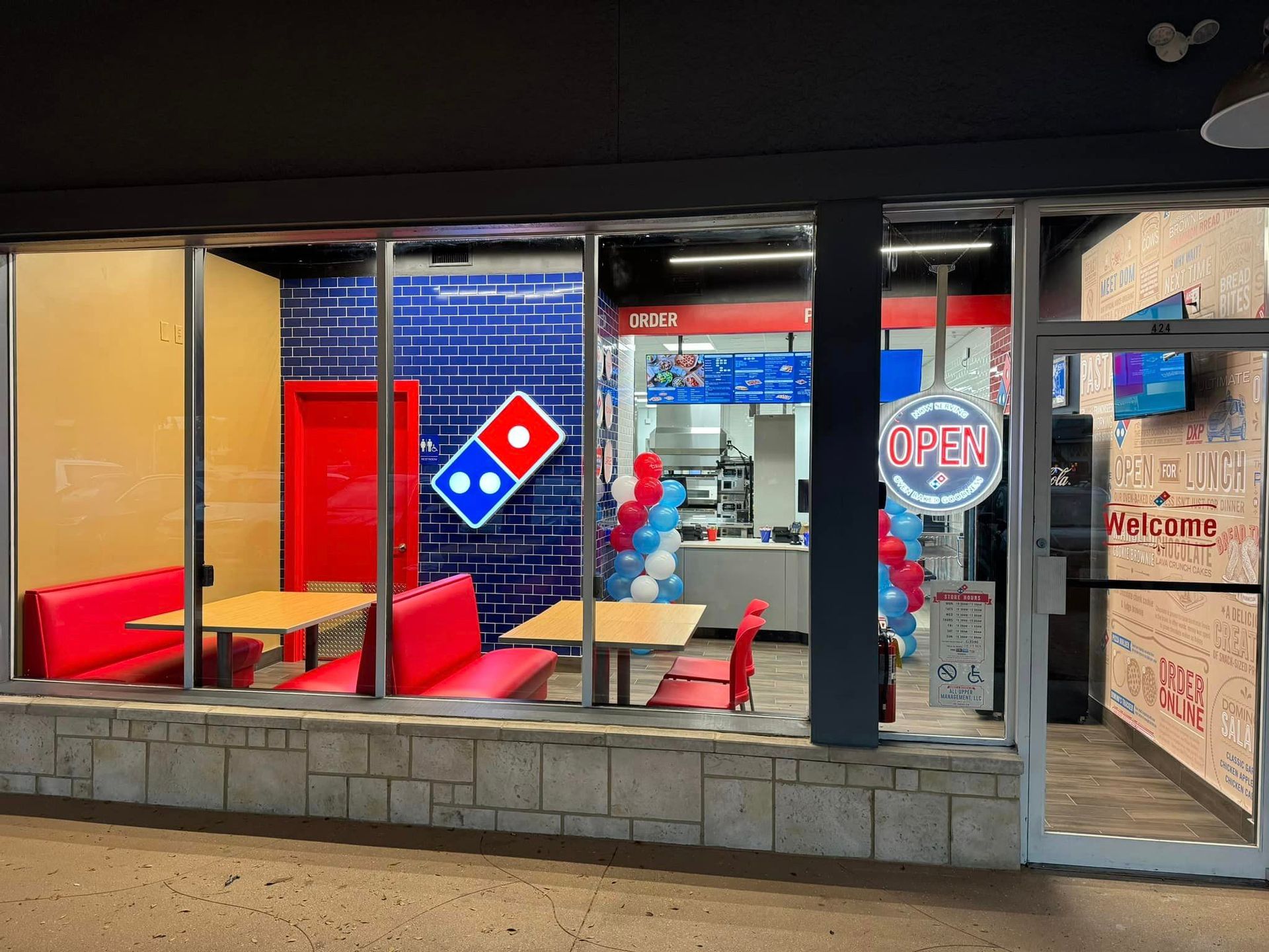 The inside of a domino 's pizza restaurant with tables and chairs.