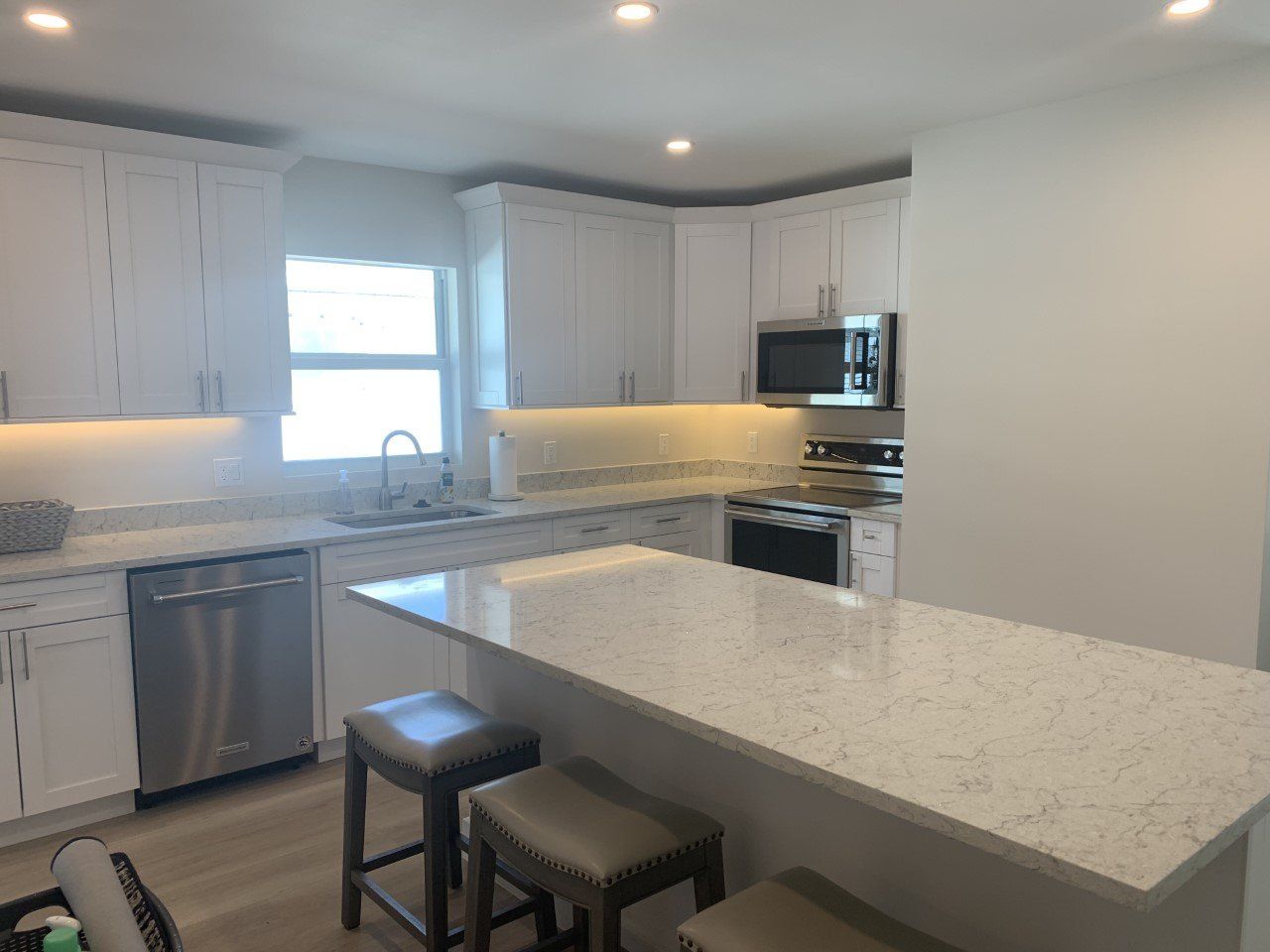 A kitchen with white cabinets and stainless steel appliances