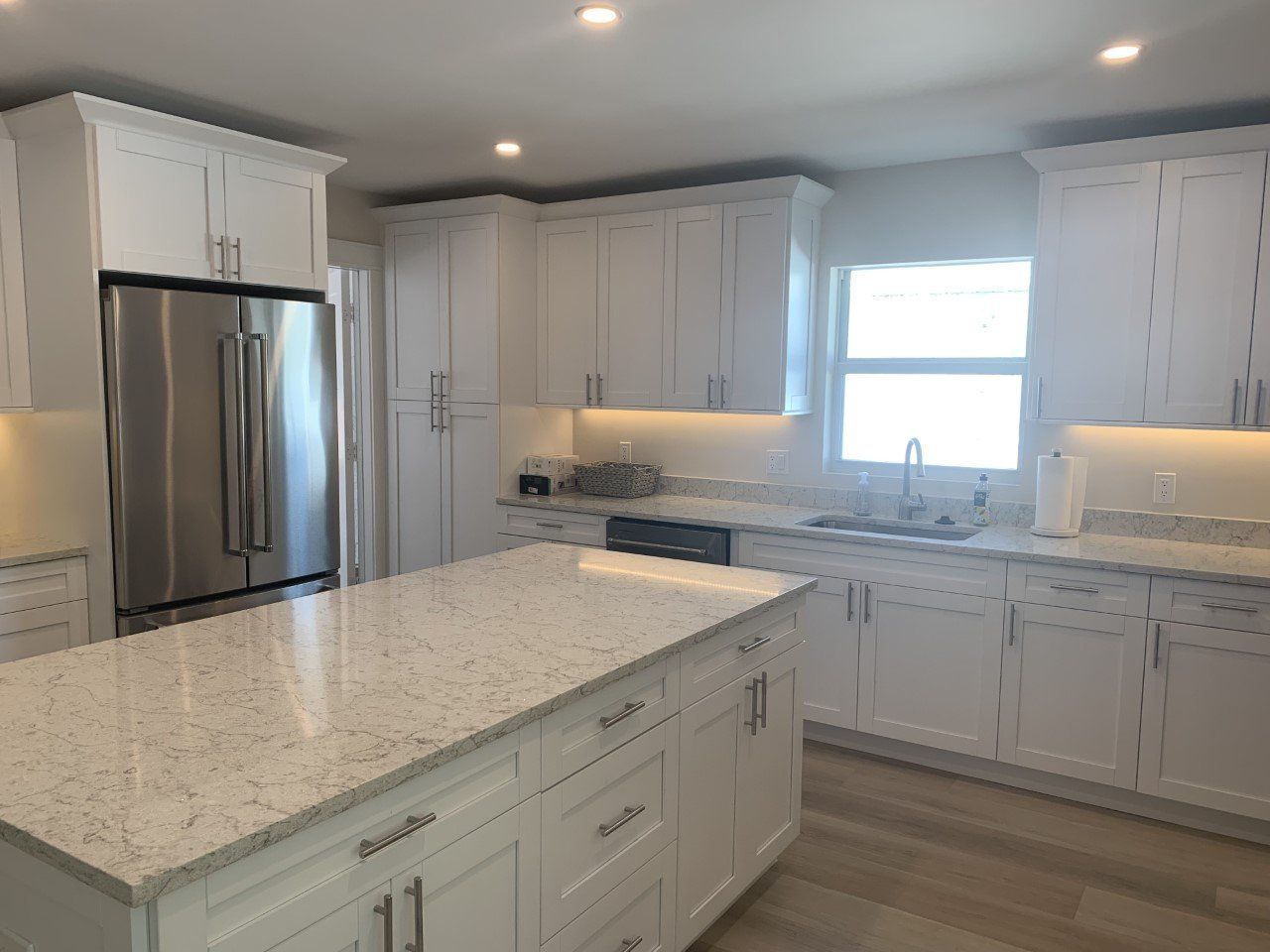 A kitchen with white cabinets and granite counter tops