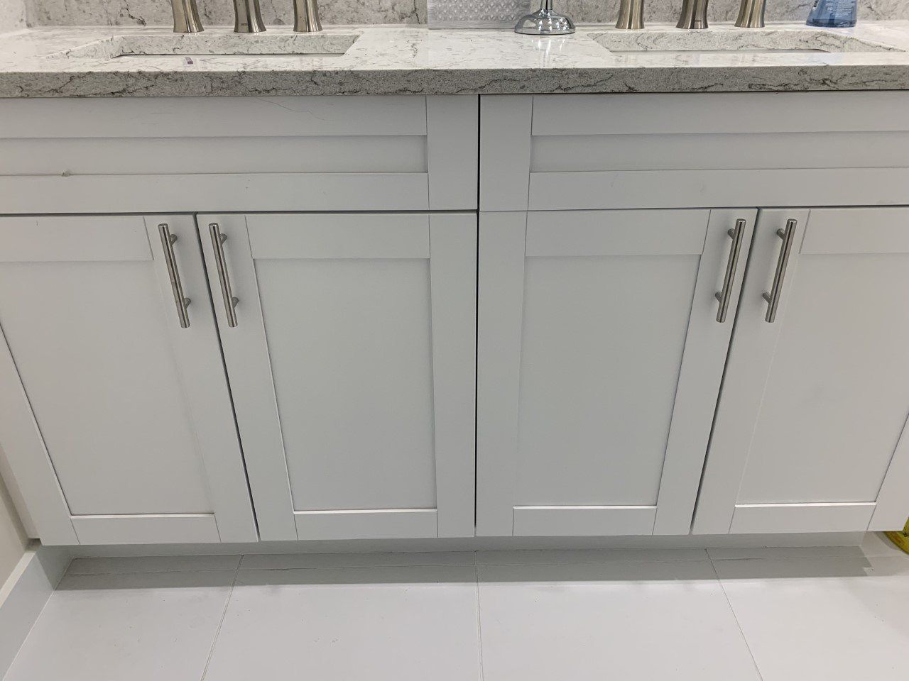 A bathroom vanity with white cabinets and a sink.
