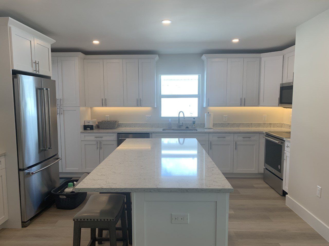 A kitchen with white cabinets and stainless steel appliances