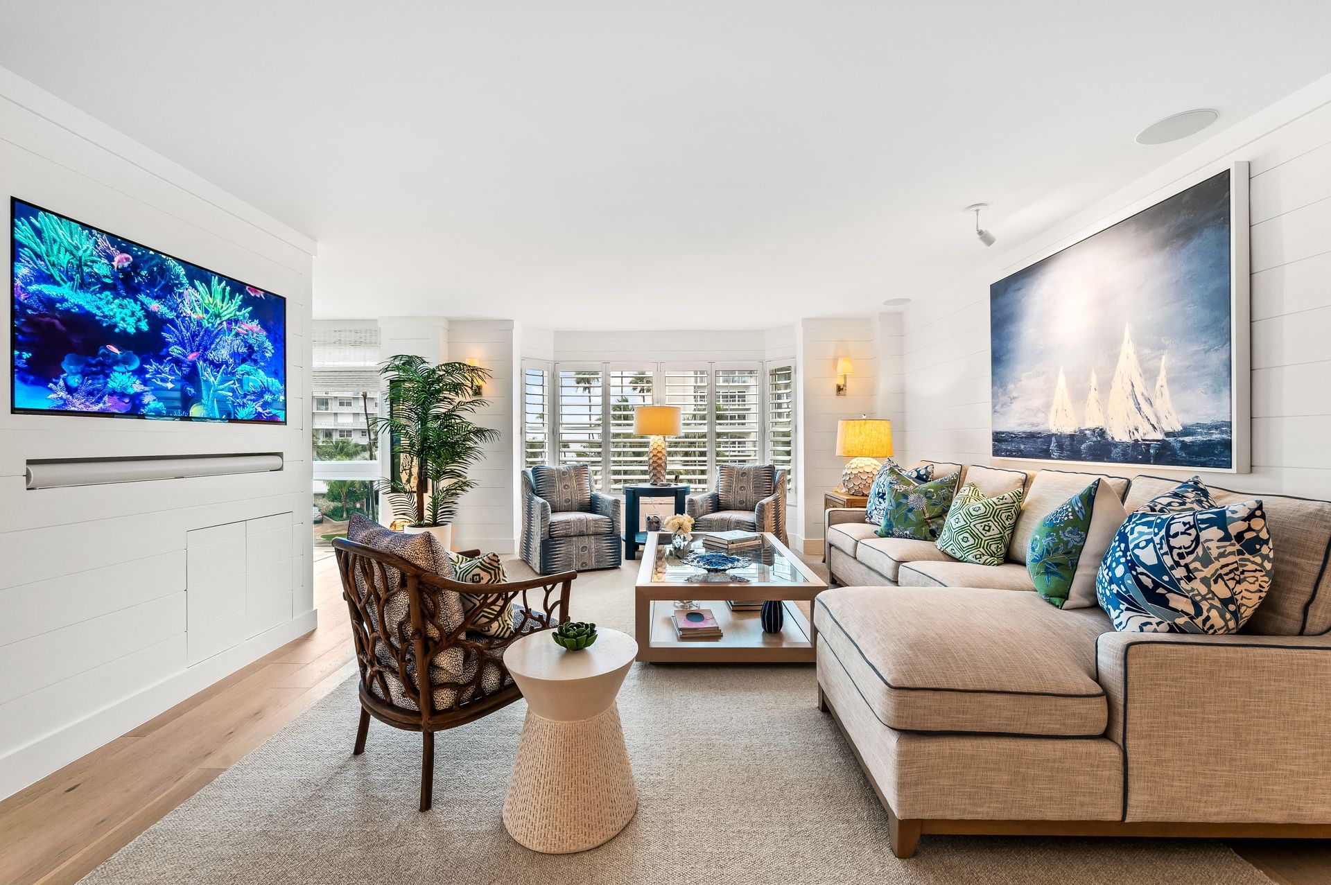 A living room with a couch , chairs , coffee table and television.