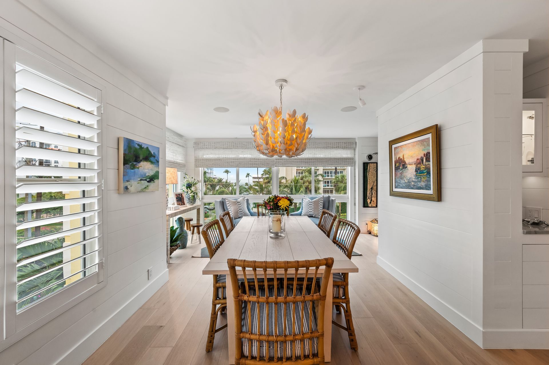 A dining room with a long table and chairs and a chandelier.