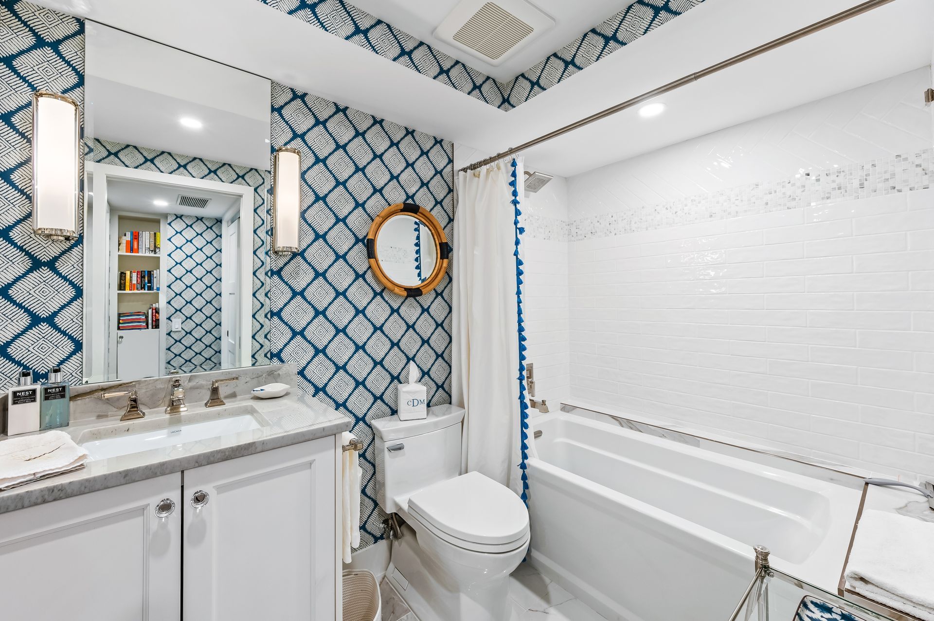 A bathroom with a toilet , sink , mirror and bathtub.