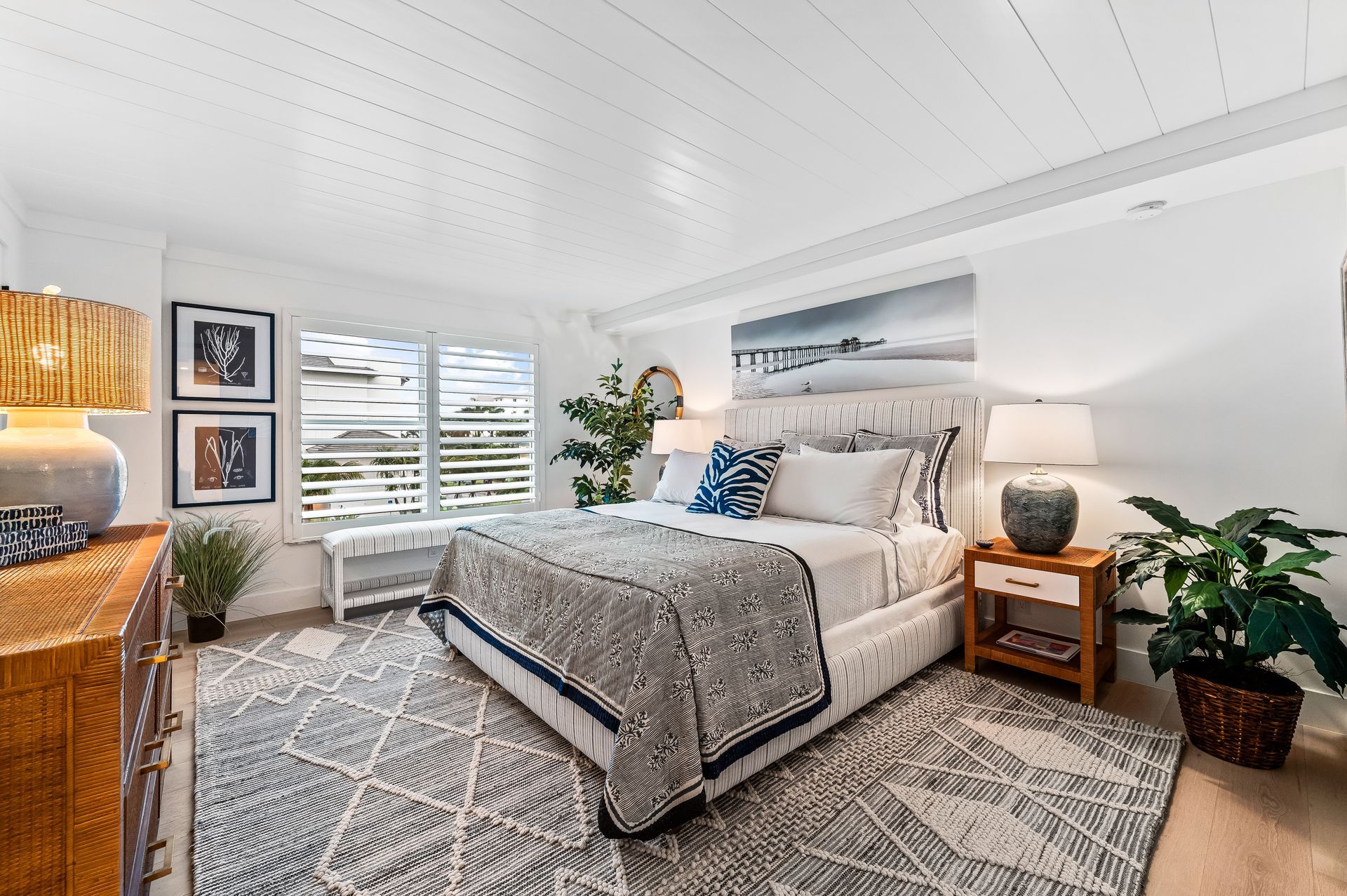 A bedroom with a large bed , dresser , nightstand , and rug.