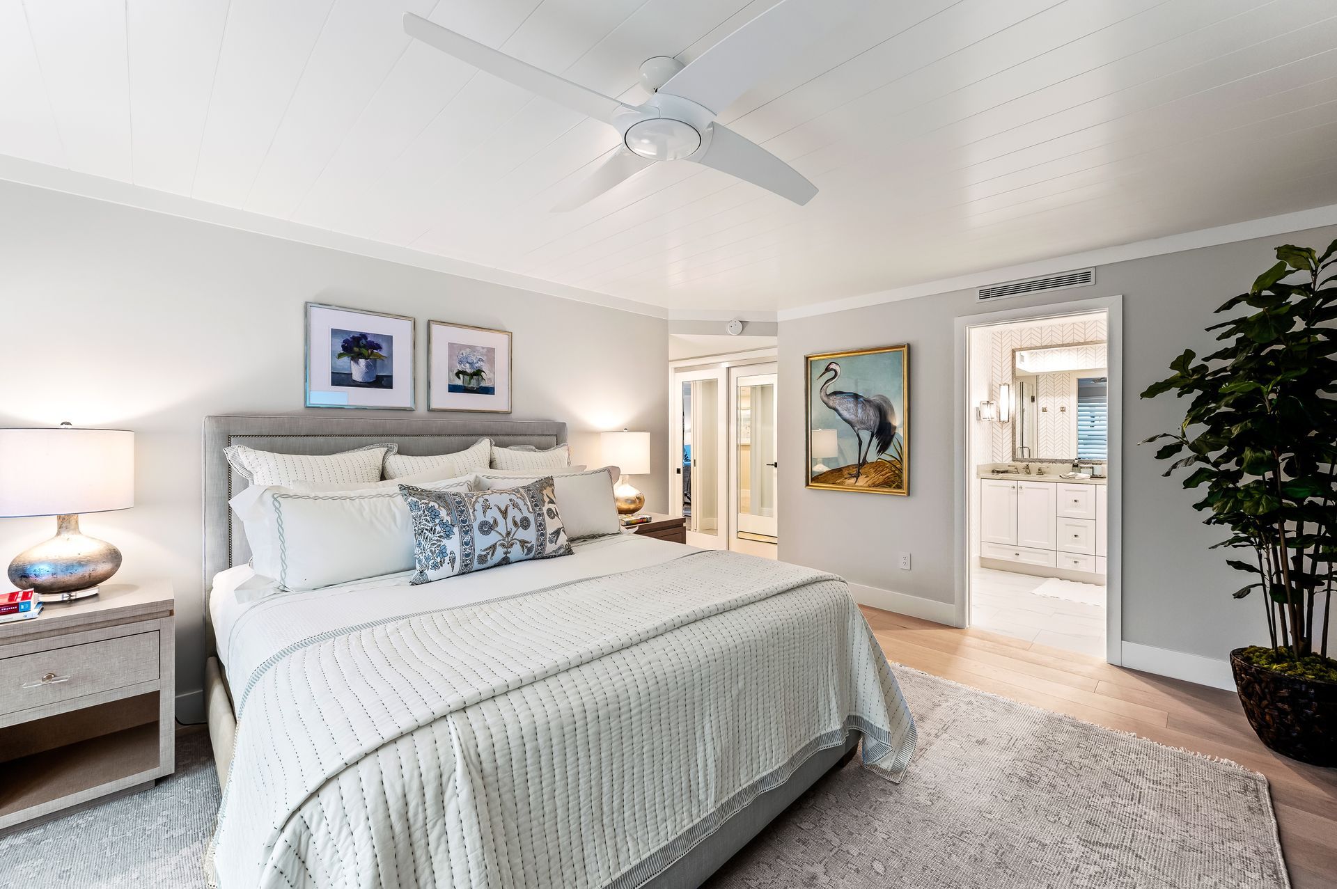 A bedroom with a large bed and a ceiling fan.