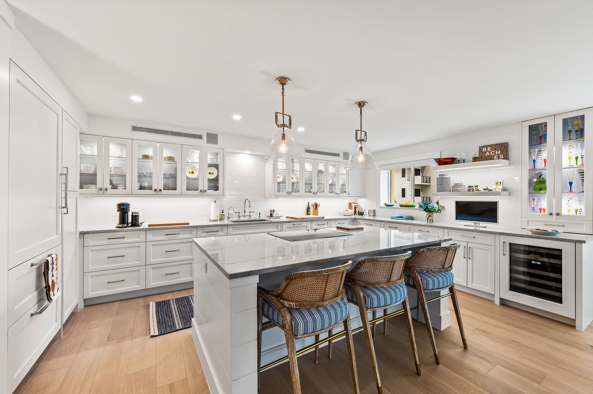 A large kitchen with white cabinets and a large island in the middle.