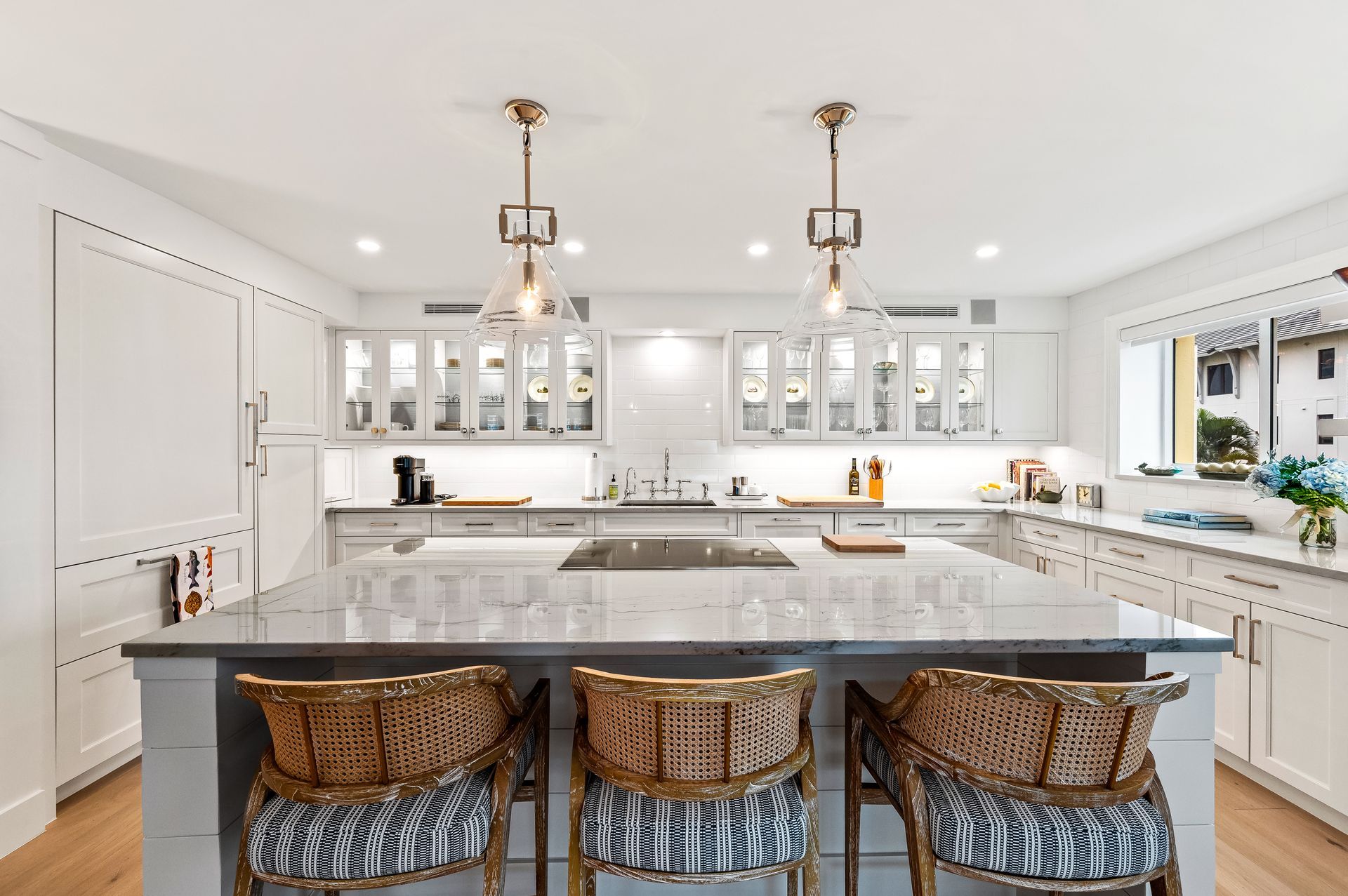 A kitchen with a large island and three chairs