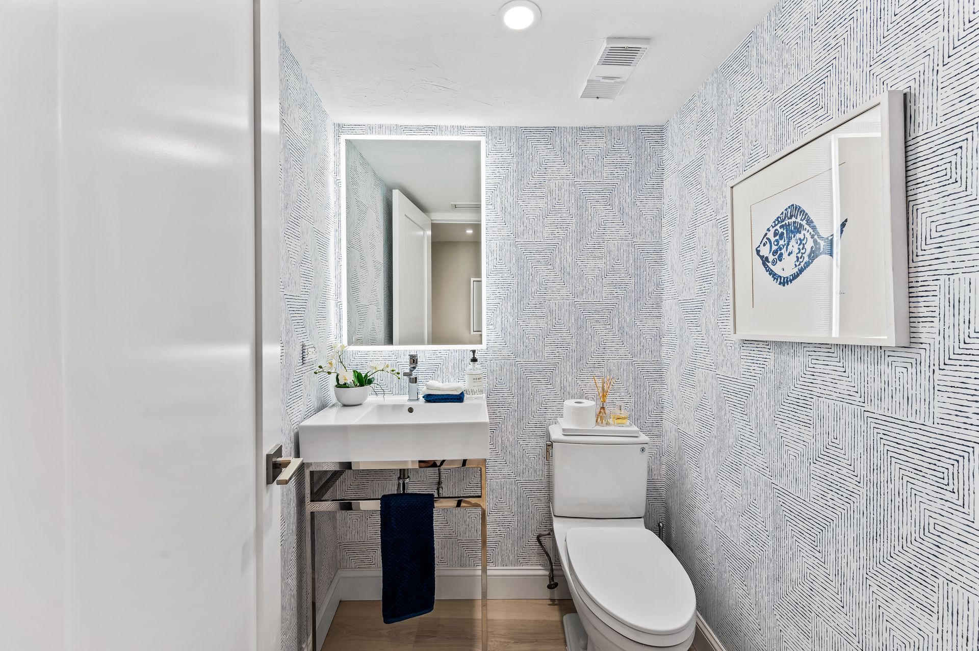 A bathroom with a toilet , sink and mirror.