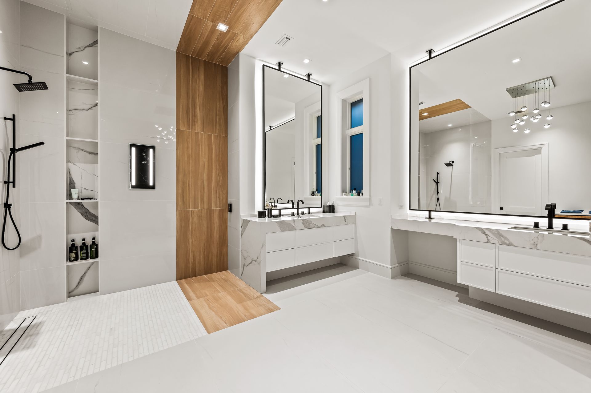 A bathroom with two sinks , a shower and a large mirror.