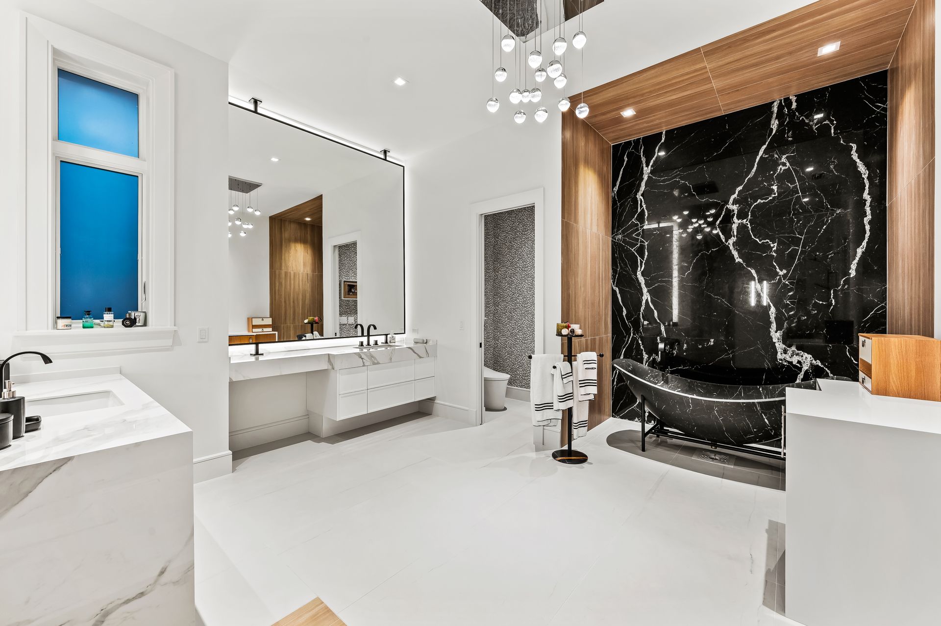 A bathroom with a bathtub , sink , mirror and window.