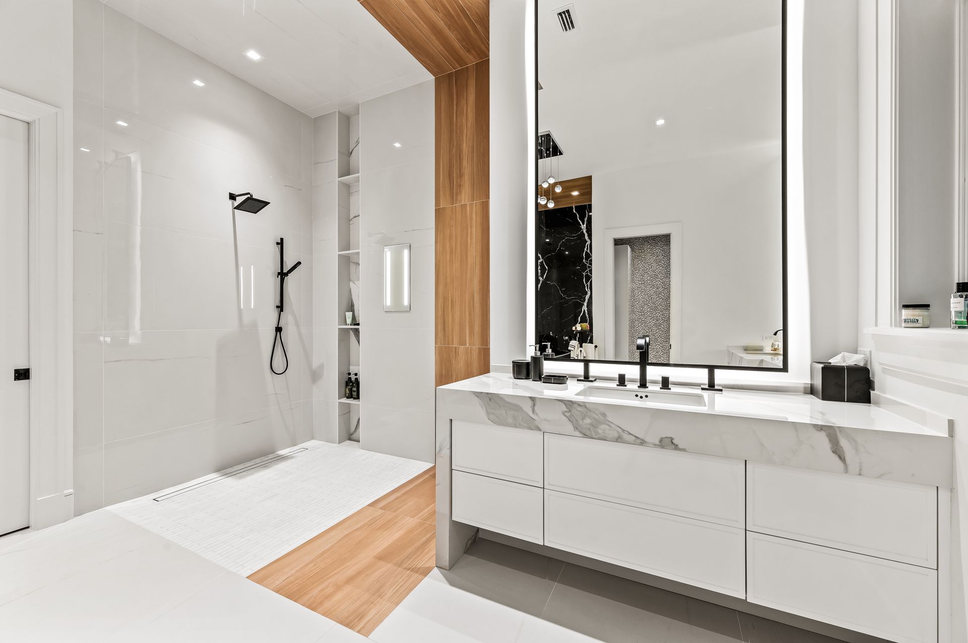 A bathroom with a sink , mirror and shower.