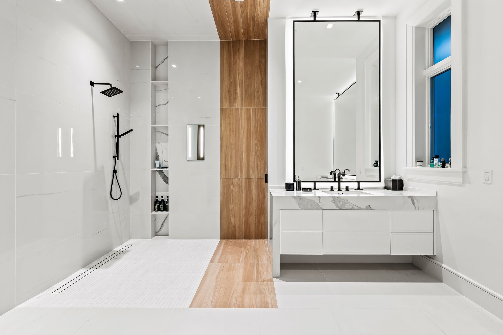 A bathroom with a sink , mirror and shower.