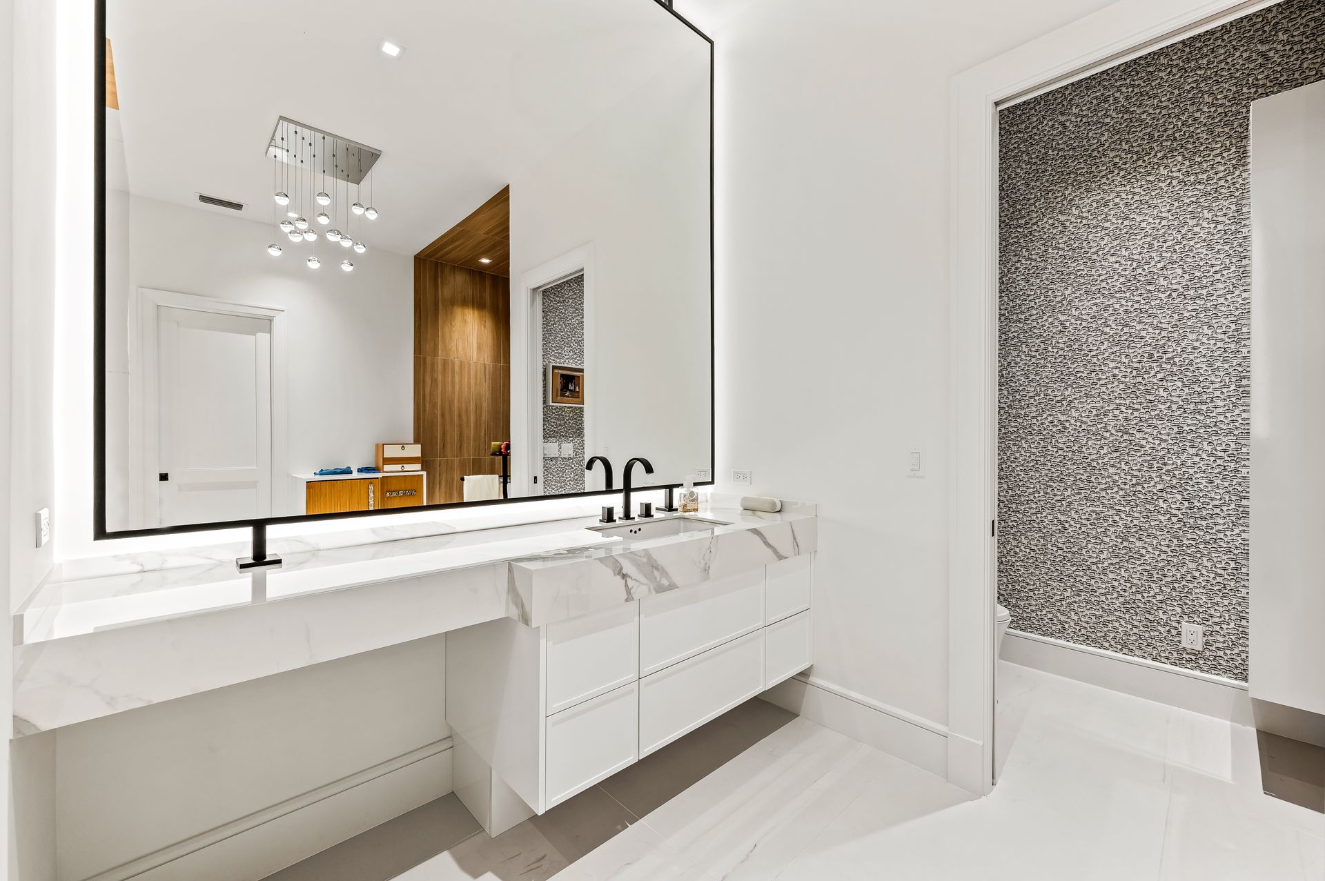 A bathroom with a large mirror and a sink.