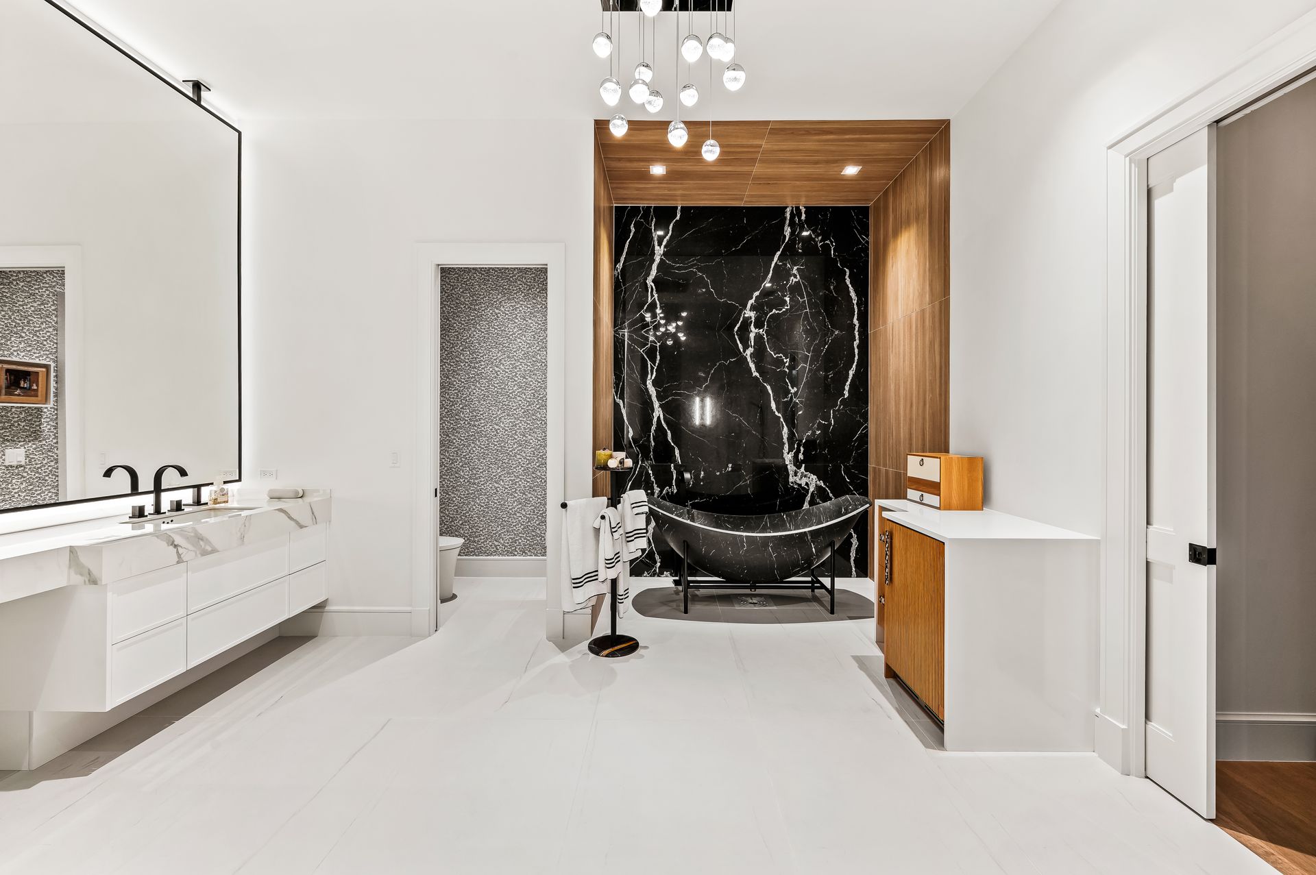 A bathroom with two sinks , a bathtub , and a large mirror.