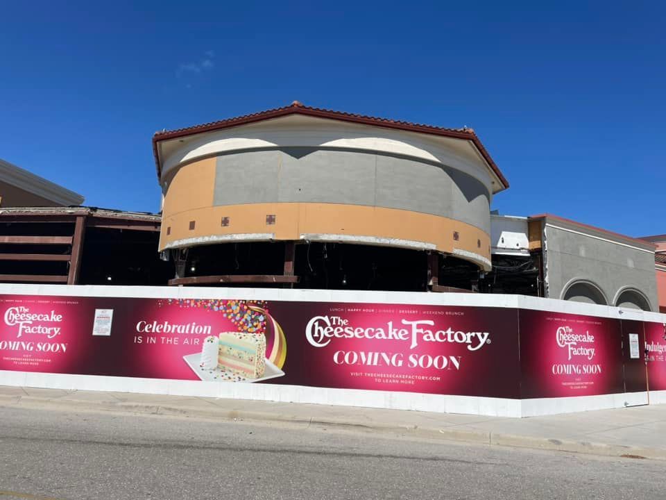 A building under construction with a sign that says cheesecake factory coming soon