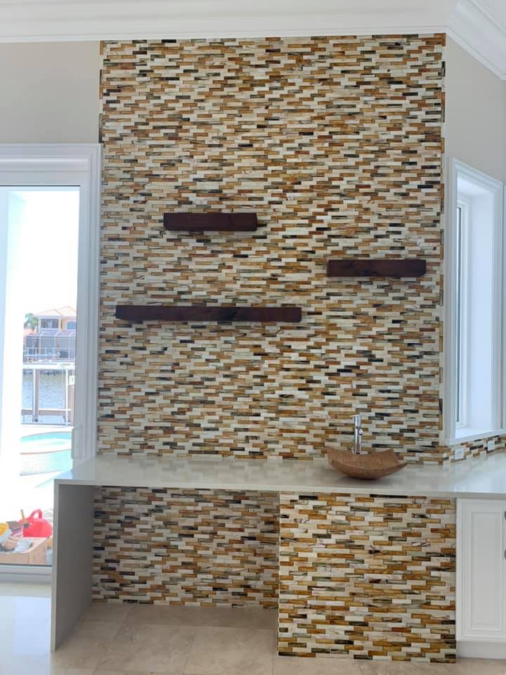 A kitchen with a stone wall and a counter top.
