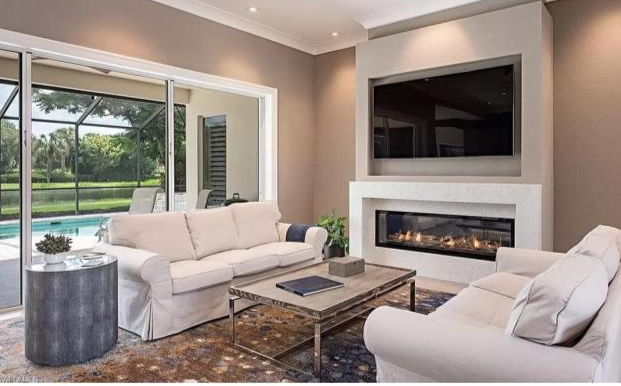 A living room with a fireplace and a flat screen tv.