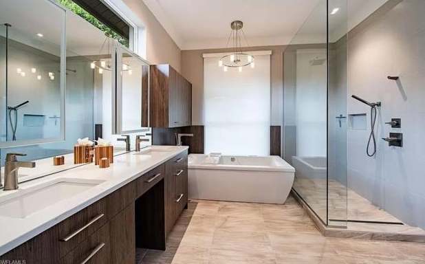 A bathroom with two sinks , a tub and a walk in shower.