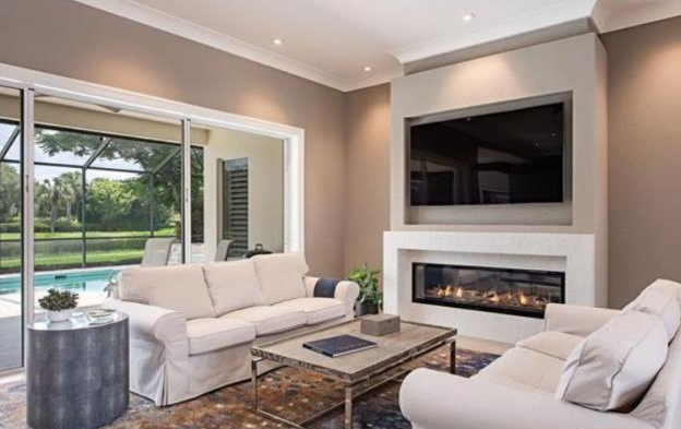 A living room with a fireplace and a flat screen tv.