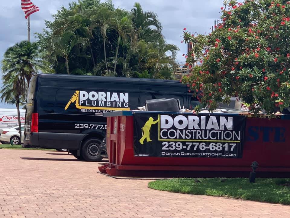 Two dorian construction vans are parked in a driveway.