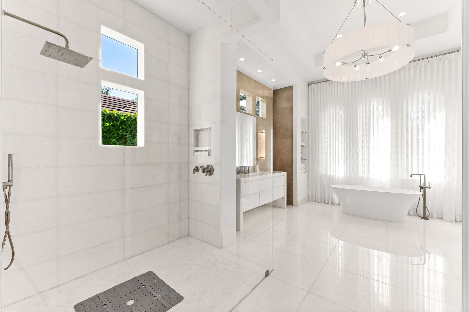 Bright white modern bathroom with shower, tub, and large windows.