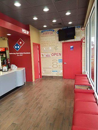 A domino 's pizza restaurant with a waiting area and a counter.