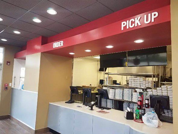 A pizza restaurant with a red sign that says pick up