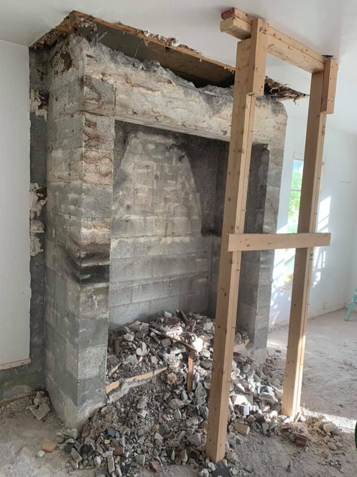 A brick fireplace with a wooden frame around it