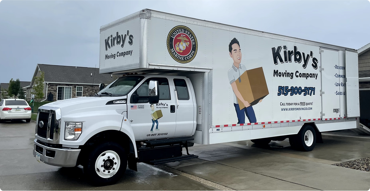 Kirby's Moving Company box truck parked on wet pavement outside a building
