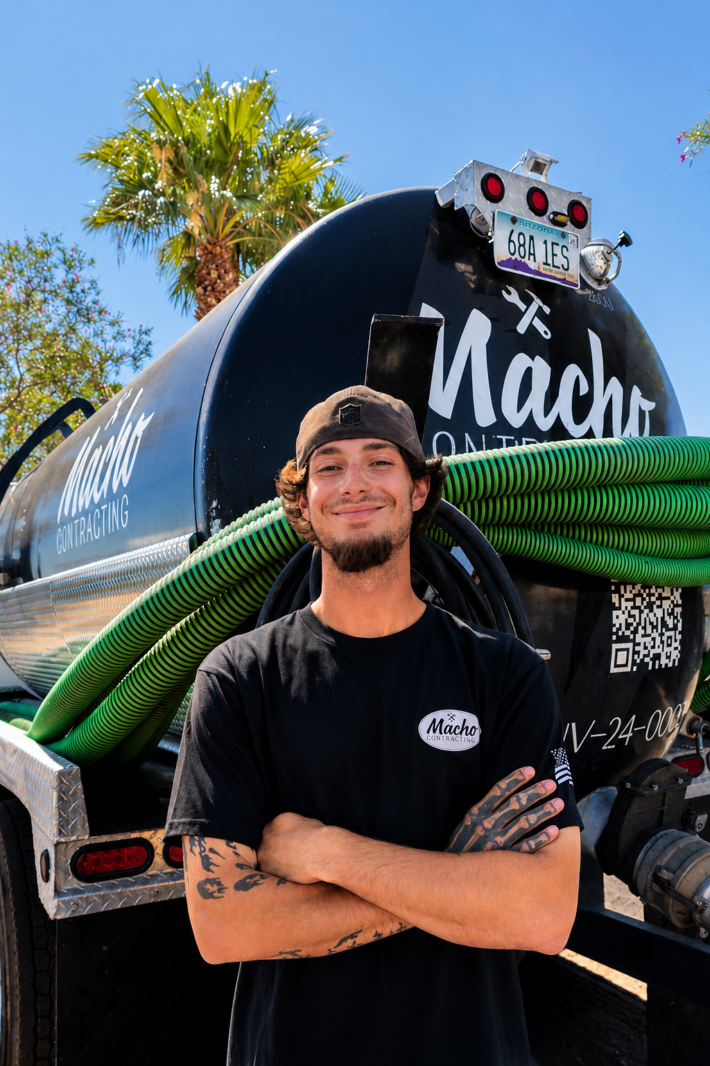 A man in a black shirt standing in front of a pump truck.