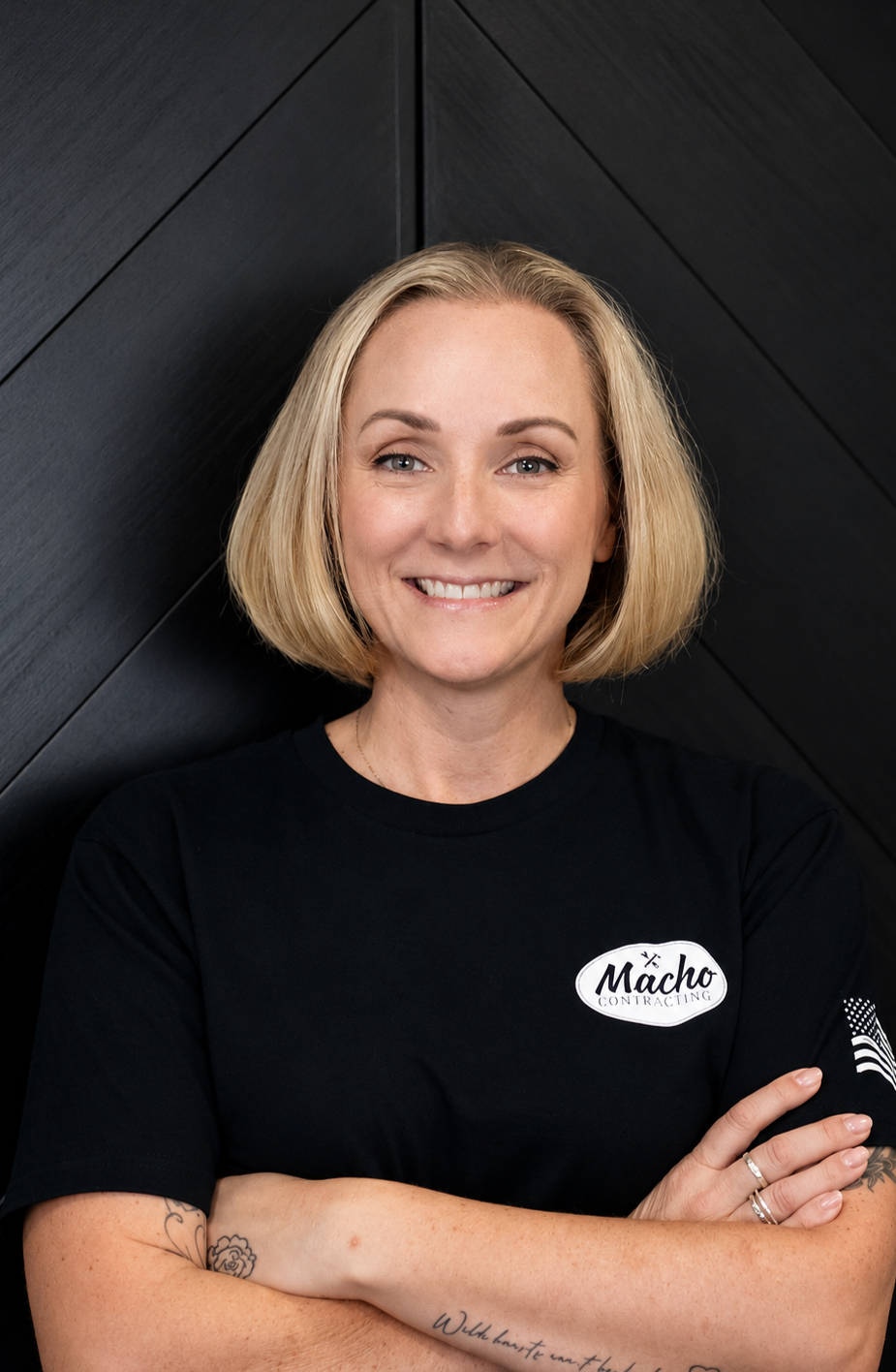 A woman wearing a black shirt with the word macho on it is taking a selfie.
