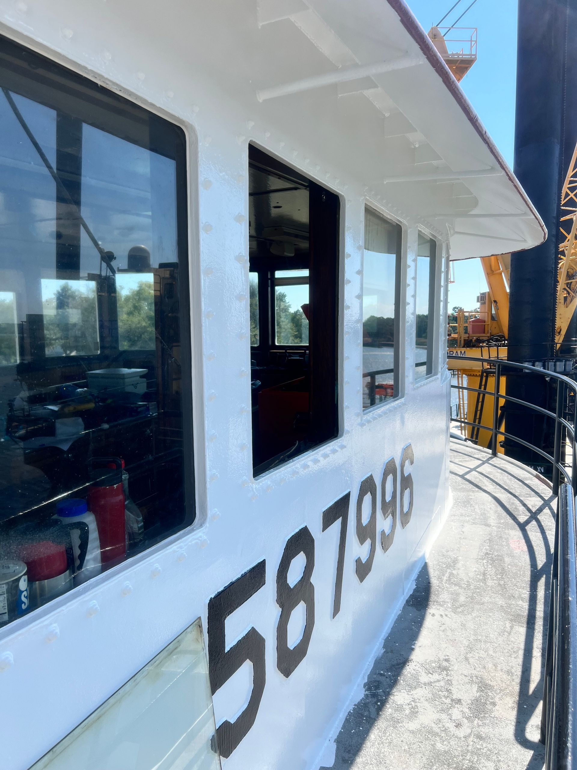 White tugboat cabin with large windows; number 587996 visible on the side.