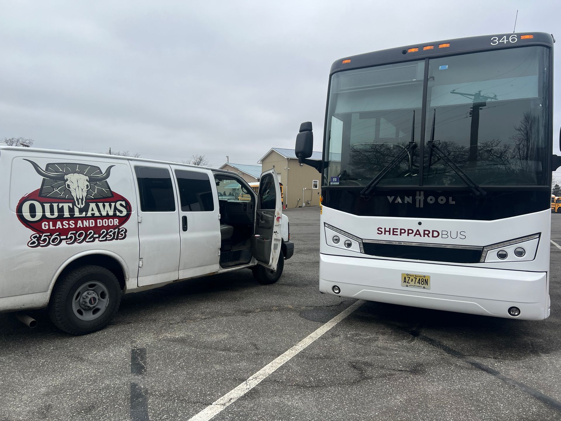 White van next to a white bus in a parking lot. The van has 