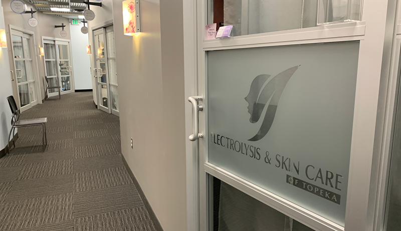 Hallway view of SOLA Salons with a frosted glass door labeled 