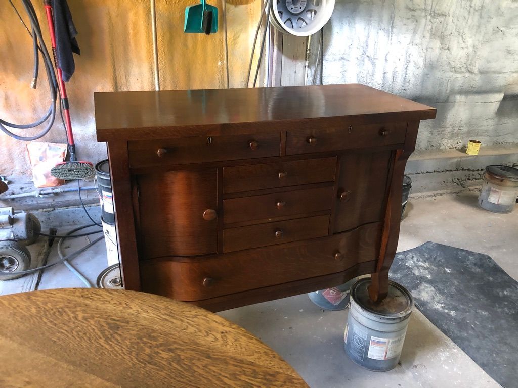 Wooden cabinet with drawers and a door, inside a workshop.