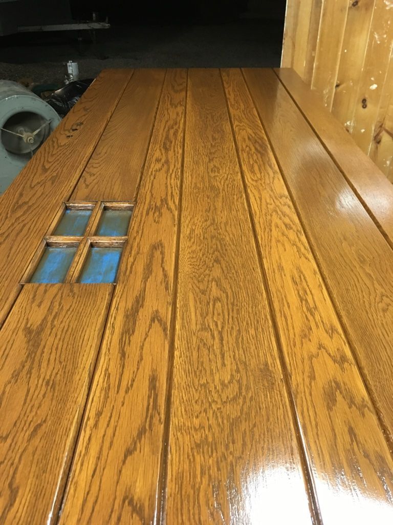 Wooden door with a window, stained brown, and glossy finish.