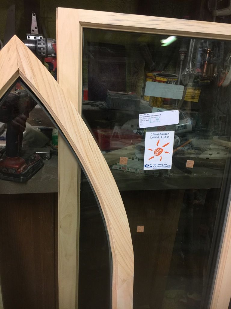 Wooden window frame, part of a glass window; workshop setting.