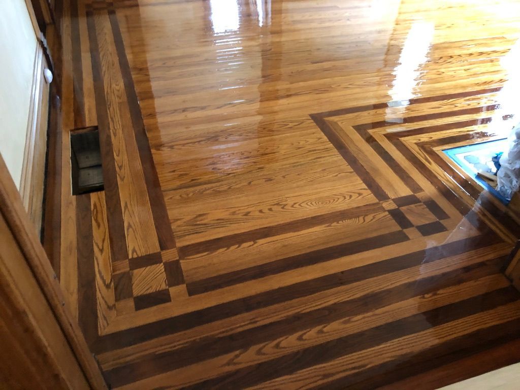 Wood floor with a dark border and geometric inlay.