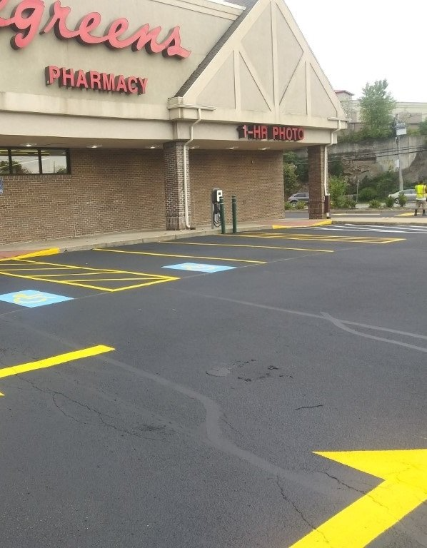Walgreens pharmacy entrance with empty parking lot and handicap spaces on an overcast day