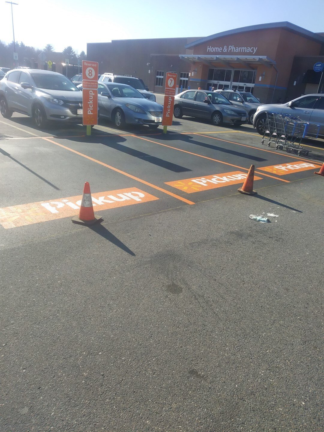 Accessible parking spaces marked with orange cones in a store parking lot