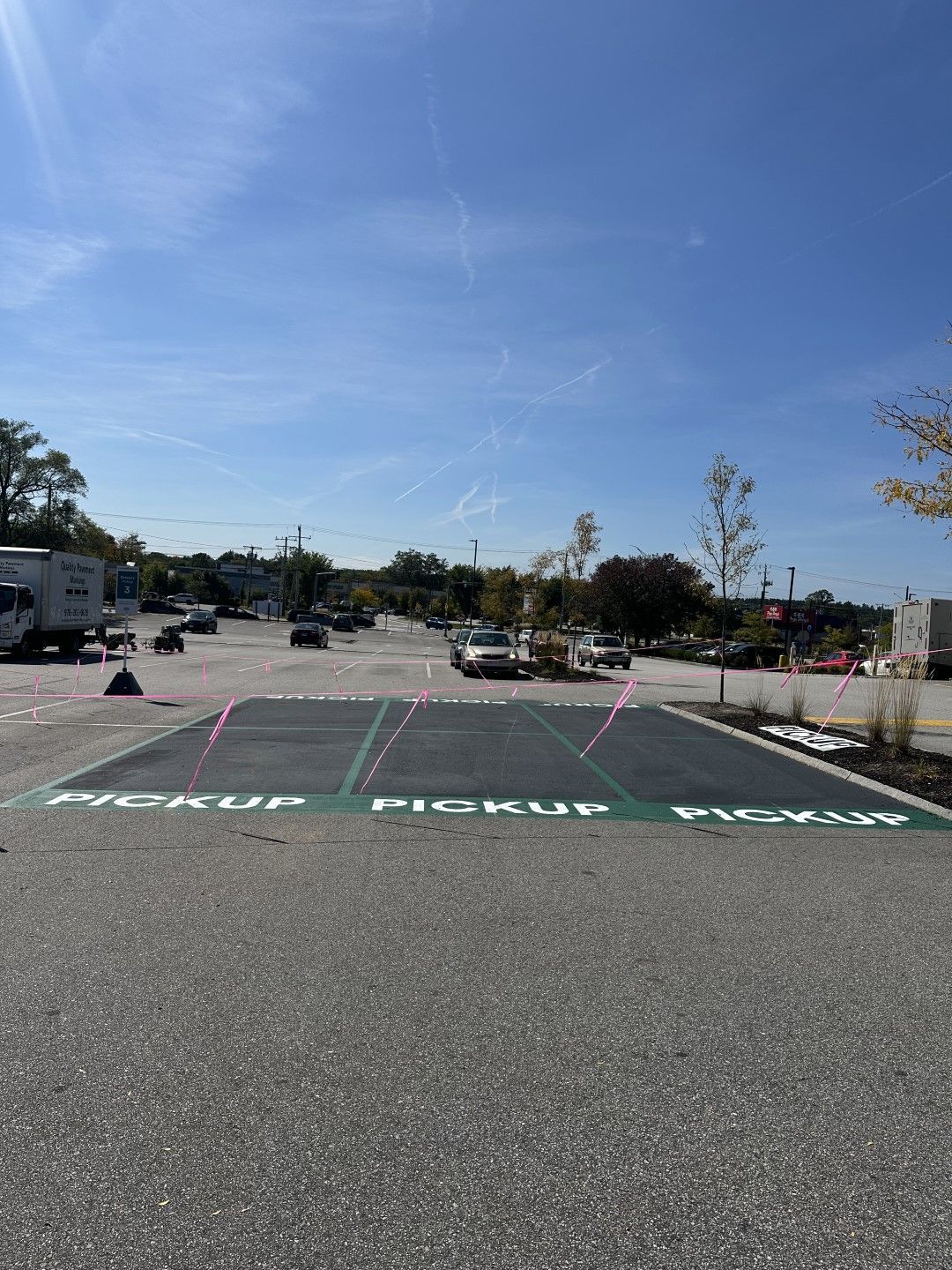 Accessible parking lot with painted pickup zone markings under a clear blue sky