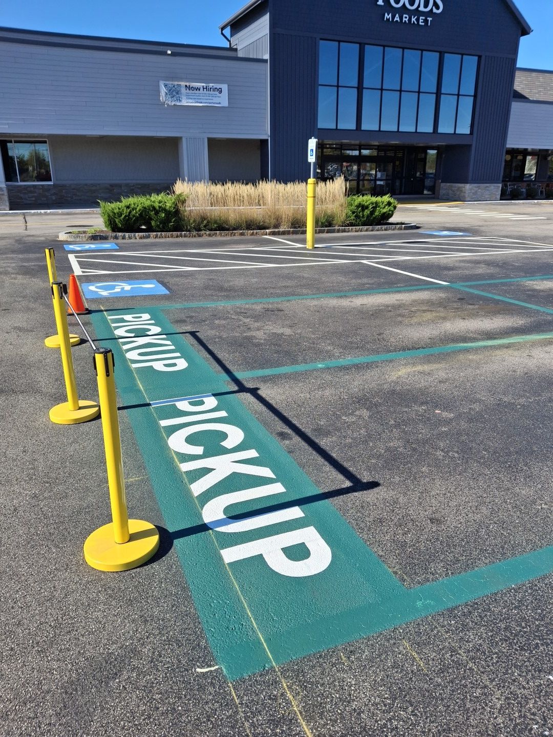 Accessible pickup parking spaces marked in blue and green outside a store entrance