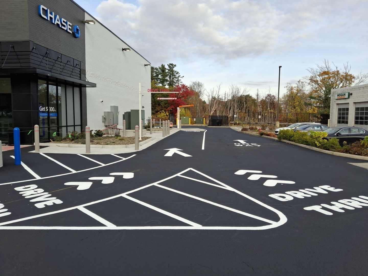 Bank drive-through lane with directional arrows beside a Chase branch on a cloudy day
