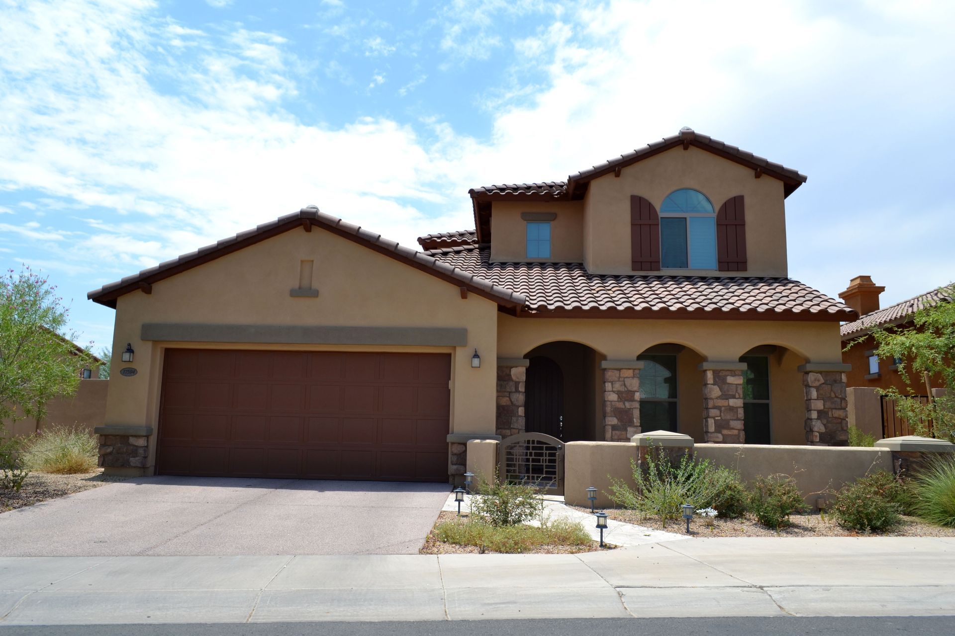 A large tan house with a brown garage door