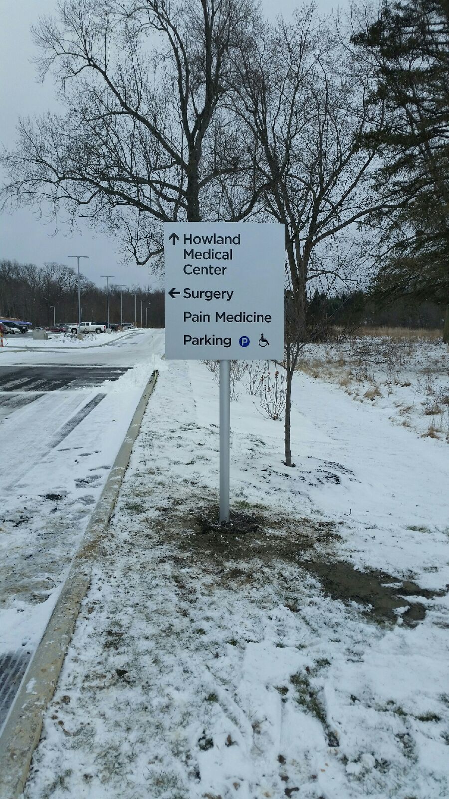 a white sign is sitting on the side of a snowy road 