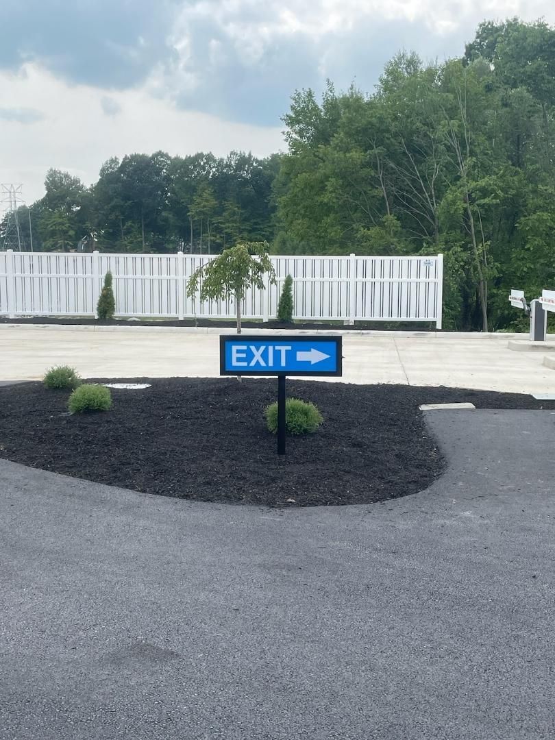 a blue exit sign is in the middle of a parking lot 