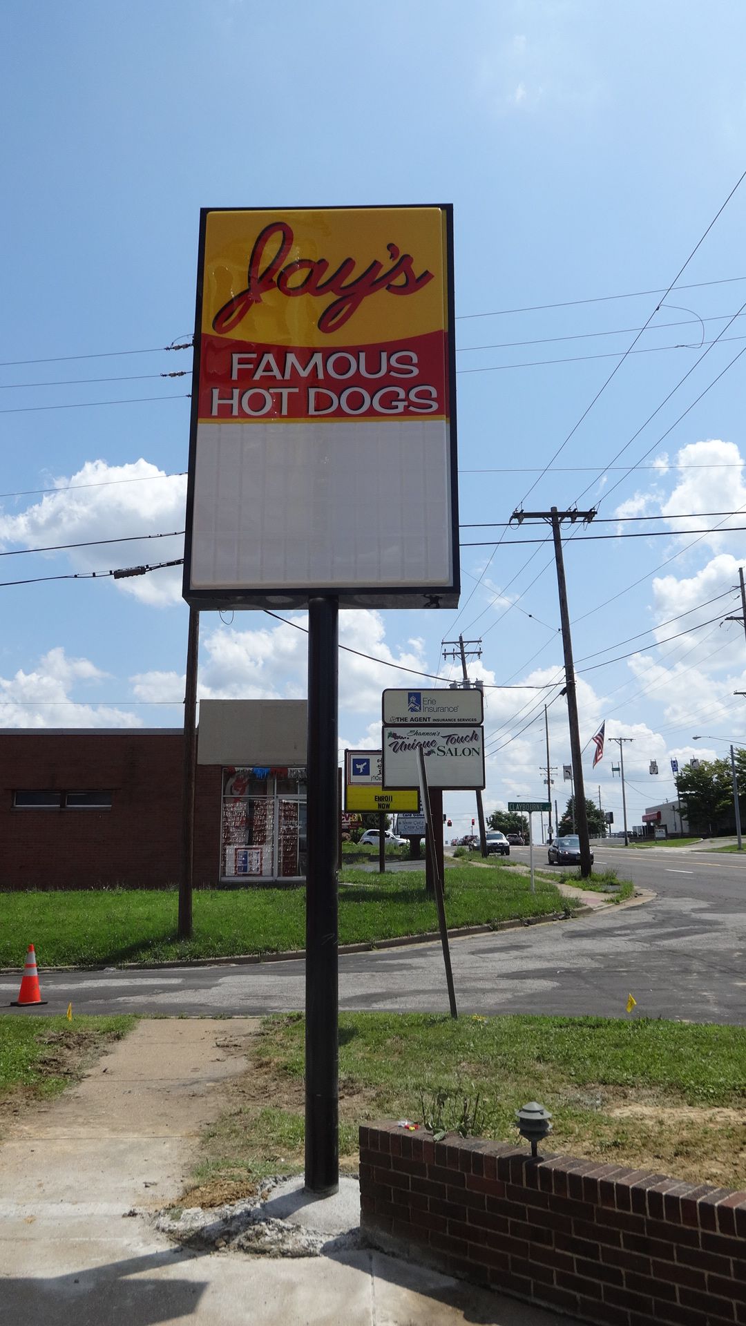 a sign for jay 's famous hot dogs on a pole